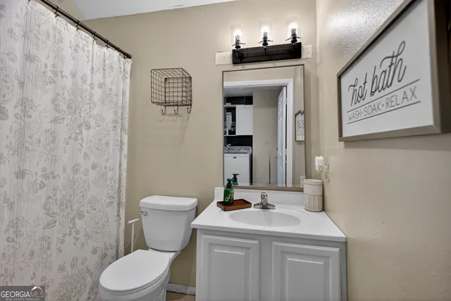 a bathroom with a toilet sink and mirror