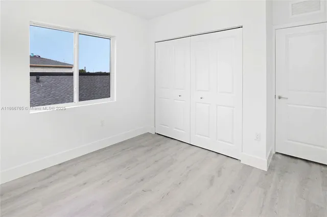 a kitchen with stainless steel appliances granite countertop a refrigerator a stove a sink and white cabinets