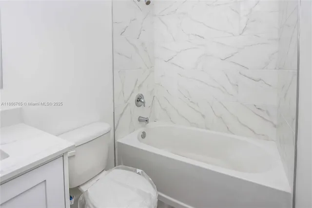 a bathroom with a sink toilet vanity and bathtub