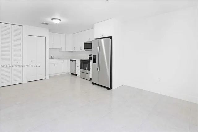 a kitchen with stainless steel appliances white cabinets and a refrigerator