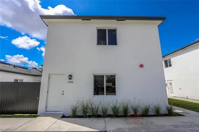 a front view of a house with plants