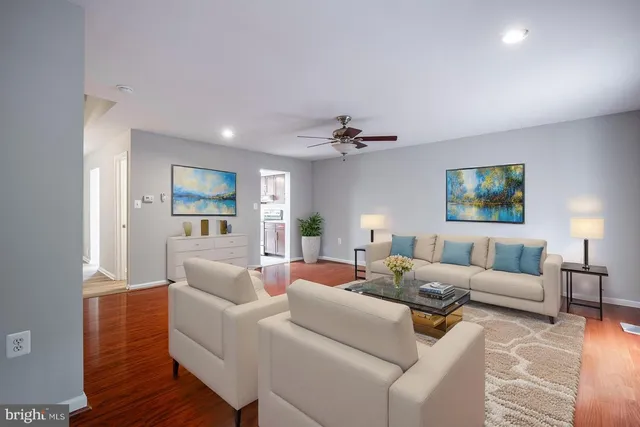 a living room with furniture and a wooden floor