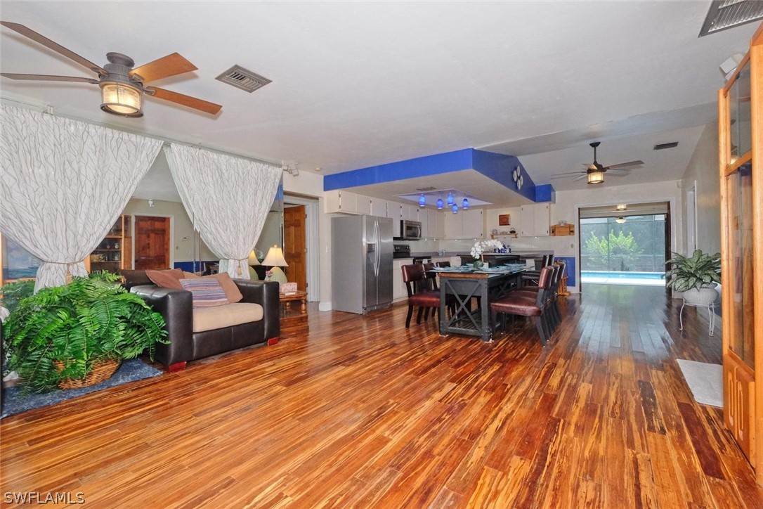 17485 Oriole Road Fort Myers, FL 33967 - Photo 5 of 35 a dining room with wooden floor a chandelier a glass table and chairs