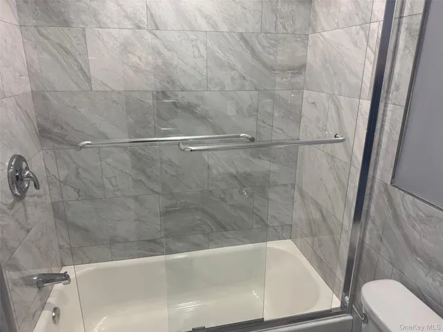 a bath tub sitting next to a white toilet and sink