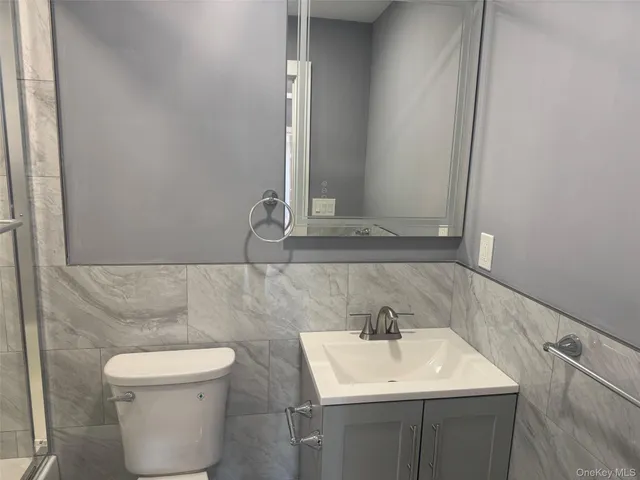 a bathroom with a sink a toilet and a mirror
