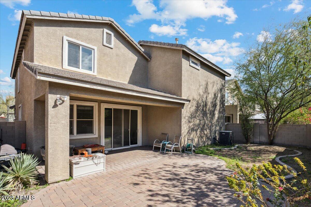 a backyard of a house with table and chairs under an umbrella