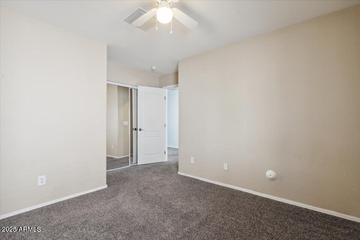 2233 East Pecan Road Phoenix, AZ 85040 - Photo 15 of 18 an empty room with a chandelier fan