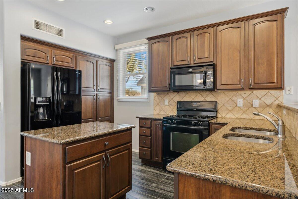 2233 East Pecan Road Phoenix, AZ 85040 - Photo 3 of 18 a kitchen with kitchen island granite countertop a sink stove and refrigerator