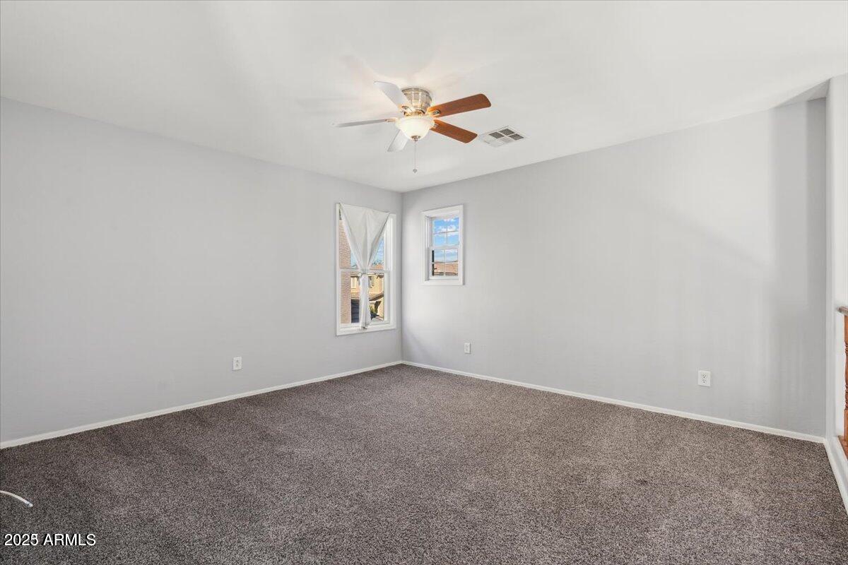2233 East Pecan Road Phoenix, AZ 85040 - Photo 9 of 18 an empty room with windows and fan