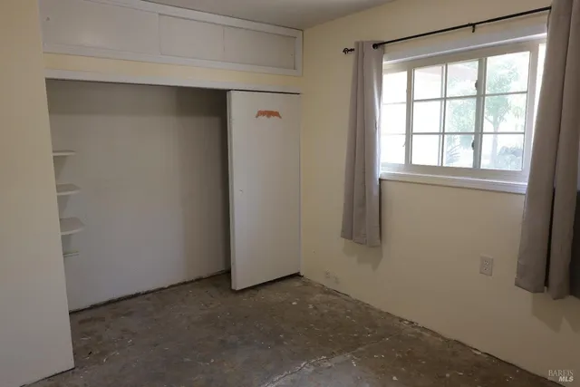 a bed sitting in a bedroom next to a window