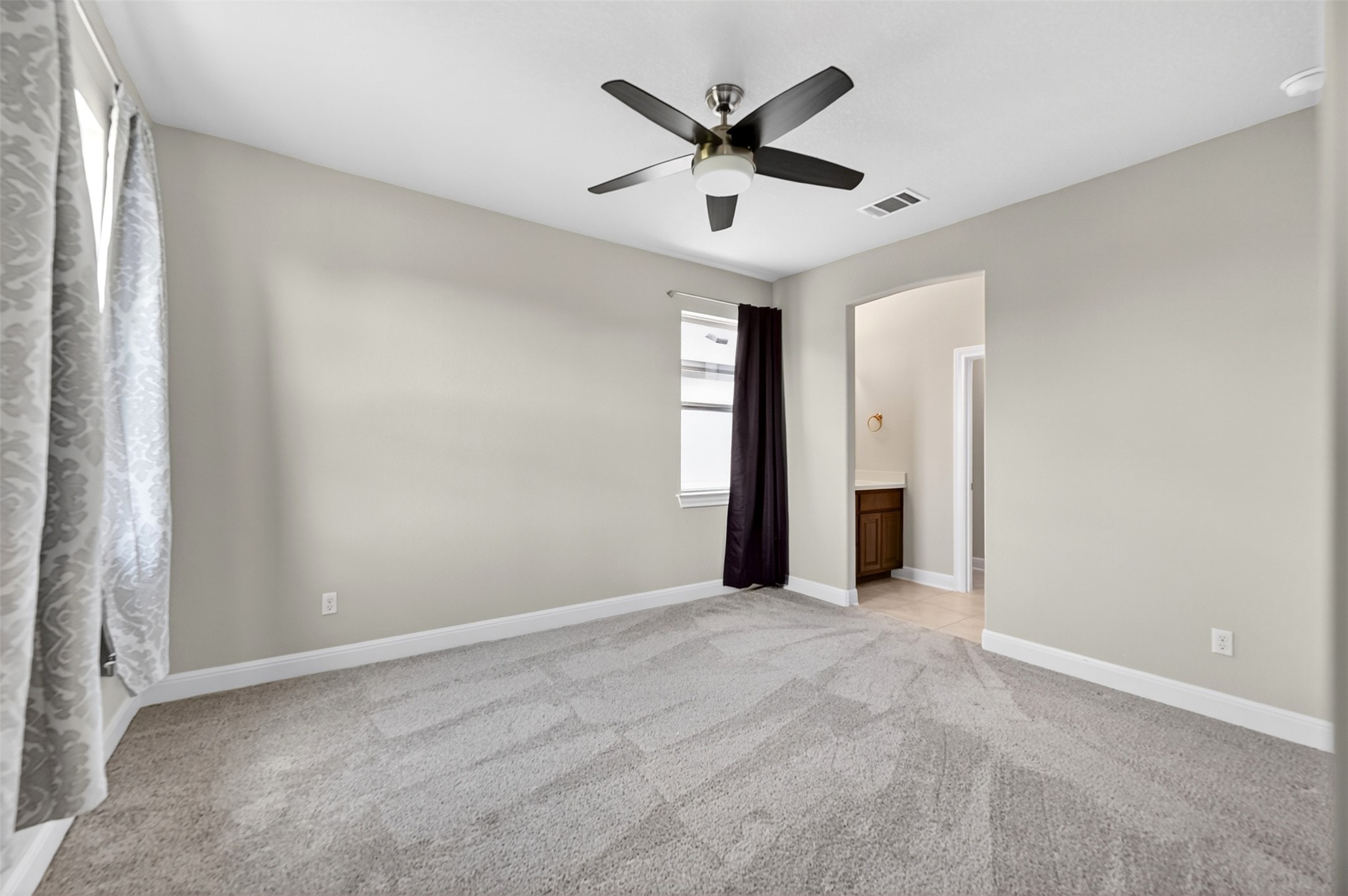 1201 Positano Pass Leander, TX 78641 - Photo 36 of 40 Expansive carpeted room featuring a ceiling fan with integrated lighting, neutral wall paint, and white baseboards