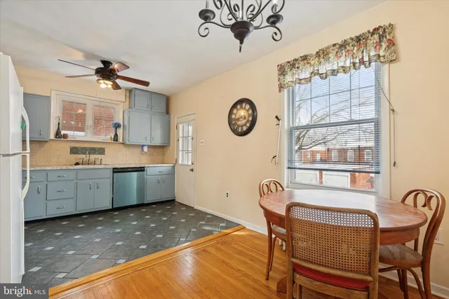 a kitchen with stainless steel appliances a stove a refrigerator a dining table and chairs