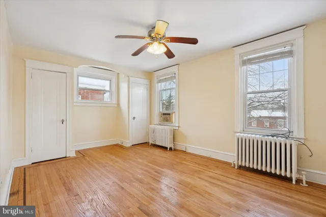 an empty room with a window and a ceiling fan