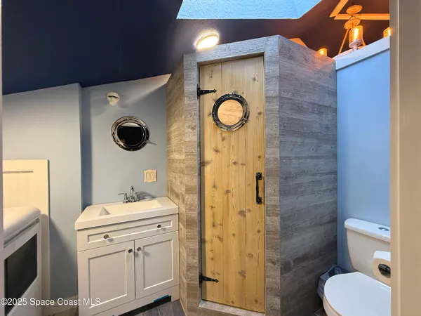 a bathroom with a sink a toilet and mirror