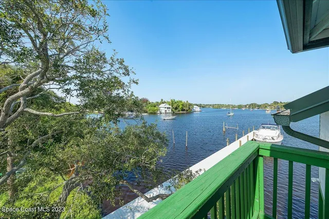 an aerial view of lake residential house with outdoor space and trees around