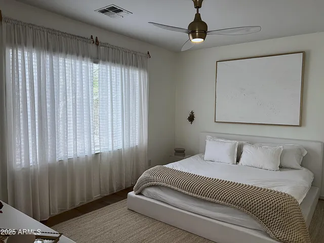 a bedroom with a large bed and a chandelier