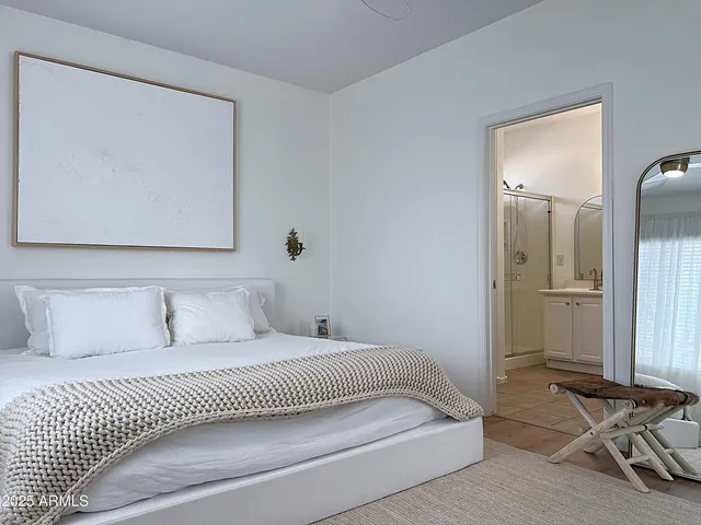 a bedroom with a bed and a painting on the wall