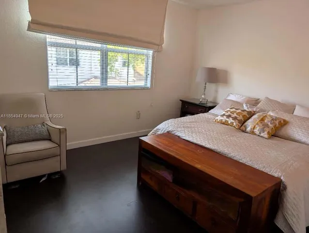 a bedroom with a bed dresser and a window