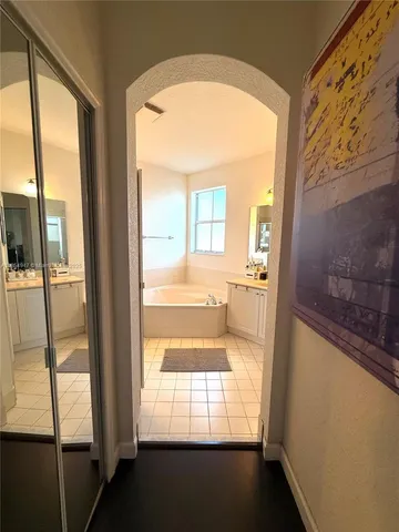 a bathroom with a tub a double vanity sink and a mirror