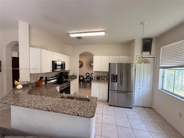a kitchen with refrigerator and microwave