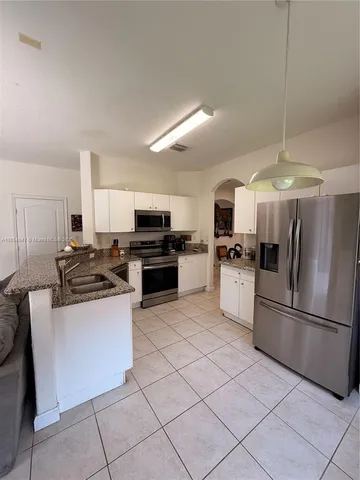 a kitchen with granite countertop a refrigerator oven a sink dishwasher and a refrigerator