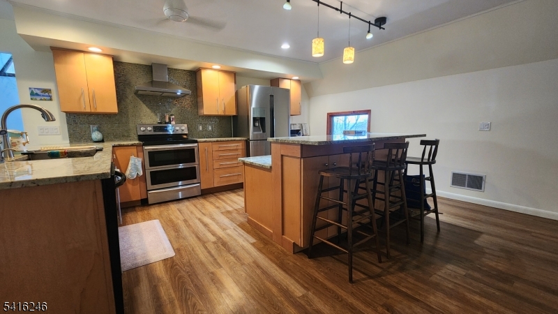 156 Lott Road Wantage, NJ 07461 - Photo 24 of 44 a kitchen with stainless steel appliances kitchen island granite countertop a stove a sink and a wooden cabinets