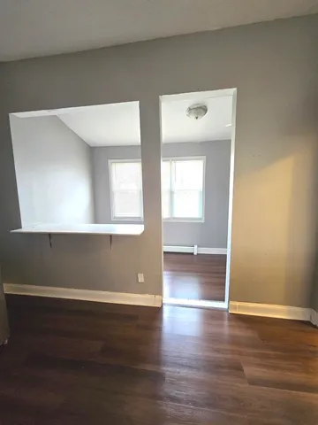 a view of an empty room with wooden floor