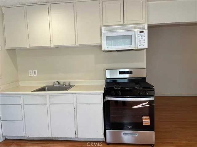 a kitchen with granite countertop white cabinets and stainless steel appliances