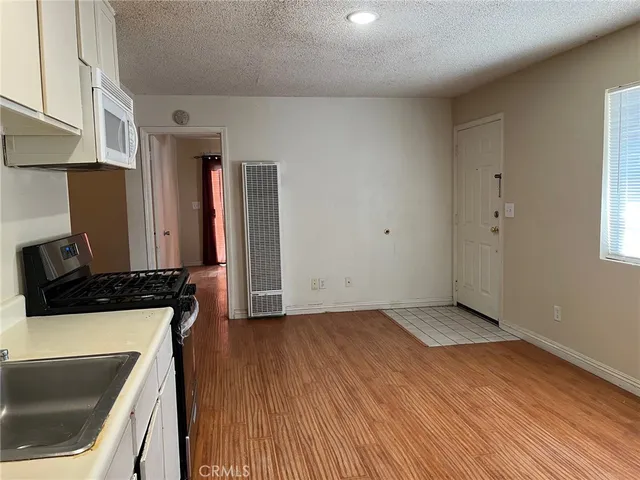 a kitchen with a wooden floor and a stove top oven