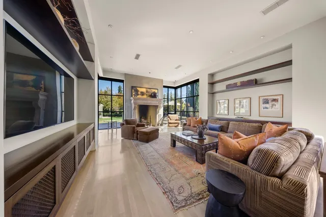 a living room with fireplace furniture and a large window