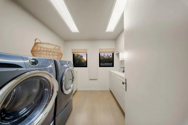 a large living room with a large window and chandelier