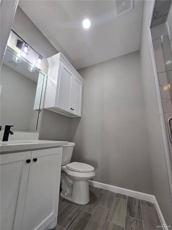 1204 Cornerstone Loop Rio Grande City, TX 78582 - Photo 8 of 15 a bathroom with a toilet a sink and wooden floor