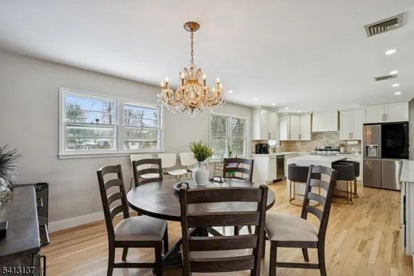 a view of a dining room with furniture a chandelier and wooden floor