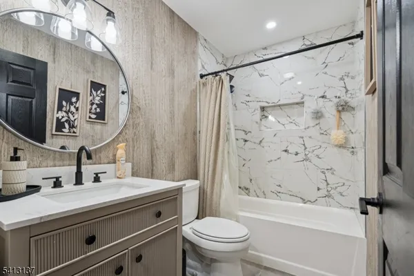 a bathroom with a granite countertop sink a toilet and a bathtub