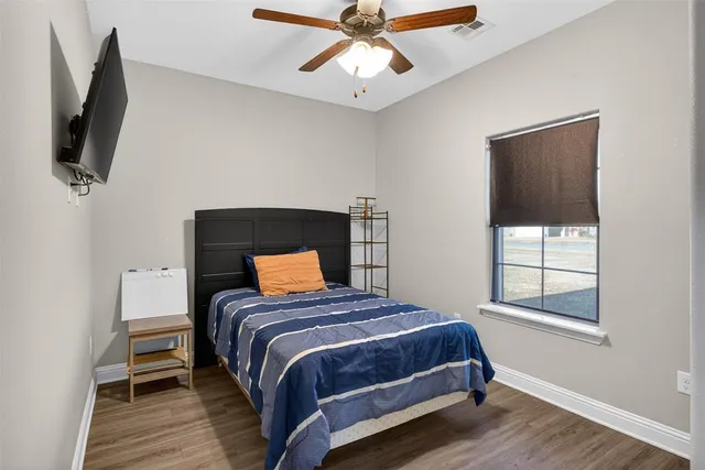 a bedroom with a bed a flat screen tv and window