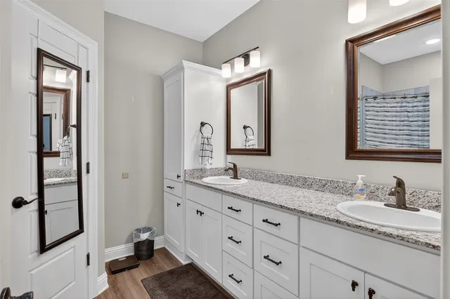 a bathroom with double sink and a mirror