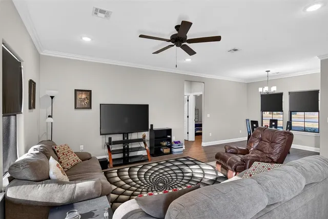 a living room with furniture and a flat screen tv with wooden floor