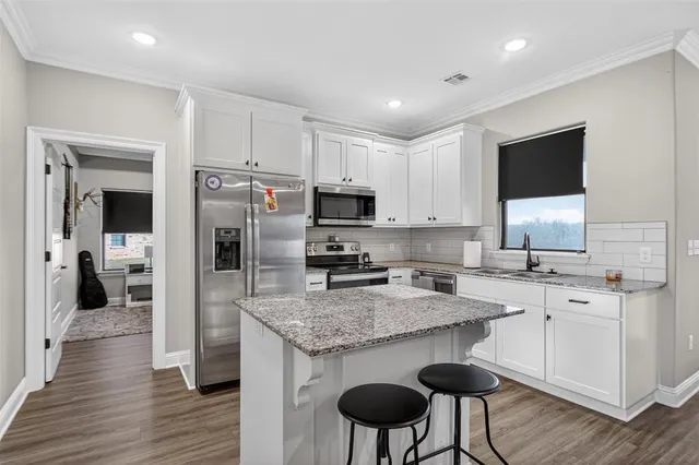a kitchen with a center island and stainless steel appliances