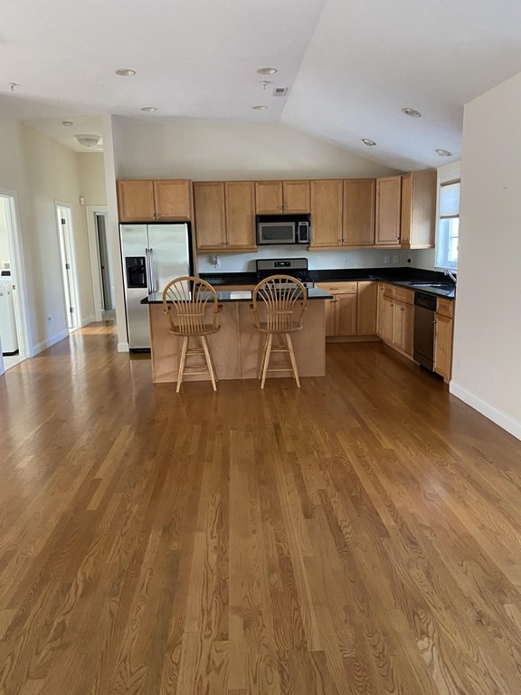 6 Essex Road, Unit 16 Ipswich, MA 01938 - Photo 7 of 14 a kitchen with stainless steel appliances a stove a sink a refrigerator white cabinets and wooden floor