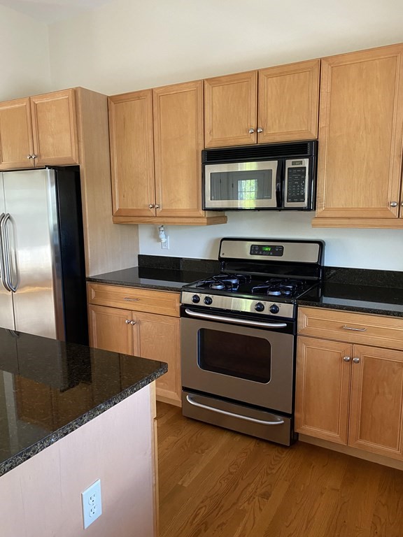6 Essex Road, Unit 16 Ipswich, MA 01938 - Photo 8 of 14 a kitchen with stainless steel appliances a stove a microwave a sink and cabinets