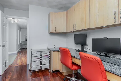 a view of a workspace with furniture and wooden floor