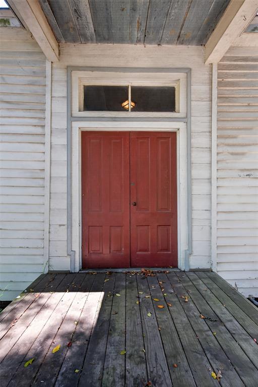 3470 State Rte 531 Dubberly, LA 71024 - Photo 13 of 34 Double panel doors with a transom window, wood siding, and a wooden porch