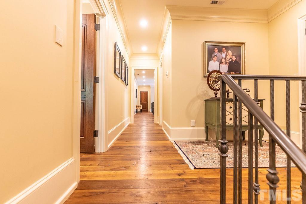 11213 Jonas Ridge Lane Raleigh, NC 27613 - Photo 46 of 100 a view of a hallway with wooden floor and staircase