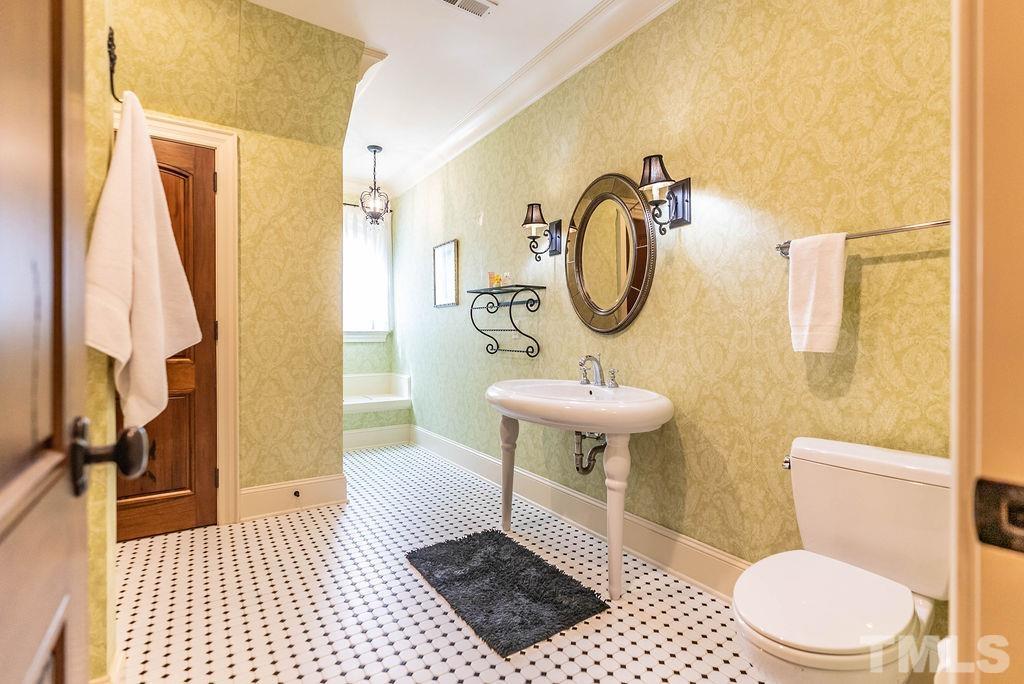 11213 Jonas Ridge Lane Raleigh, NC 27613 - Photo 54 of 100 a bathroom with a toilet a sink and a mirror