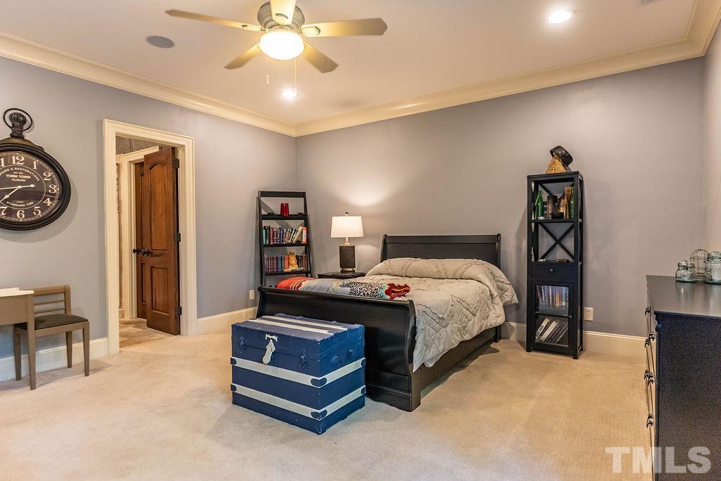 11213 Jonas Ridge Lane Raleigh, NC 27613 - Photo 61 of 100 a bedroom with a bed and a chandelier