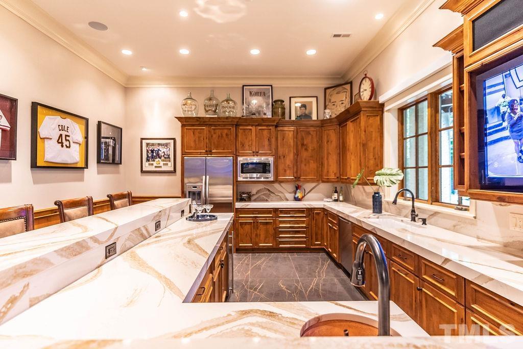 11213 Jonas Ridge Lane Raleigh, NC 27613 - Photo 67 of 100 a kitchen with stainless steel appliances granite countertop a sink dishwasher and cabinets with wooden floor