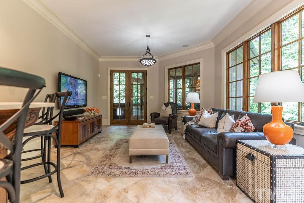 11213 Jonas Ridge Lane Raleigh, NC 27613 - Photo 94 of 100 a living room with furniture a flat screen tv and a chandelier