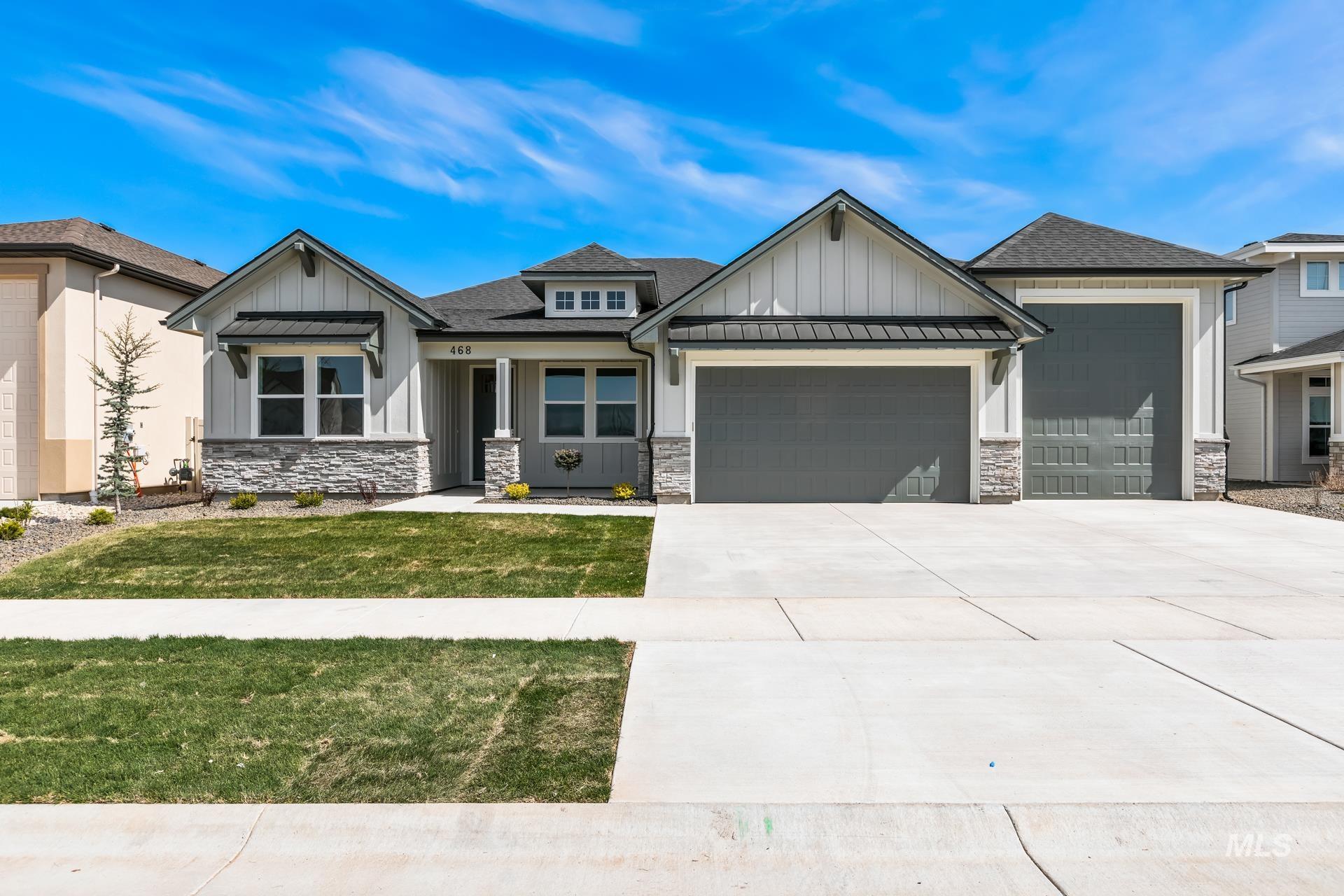 View of front of home with board and batten siding, a garage, and roof with shingles