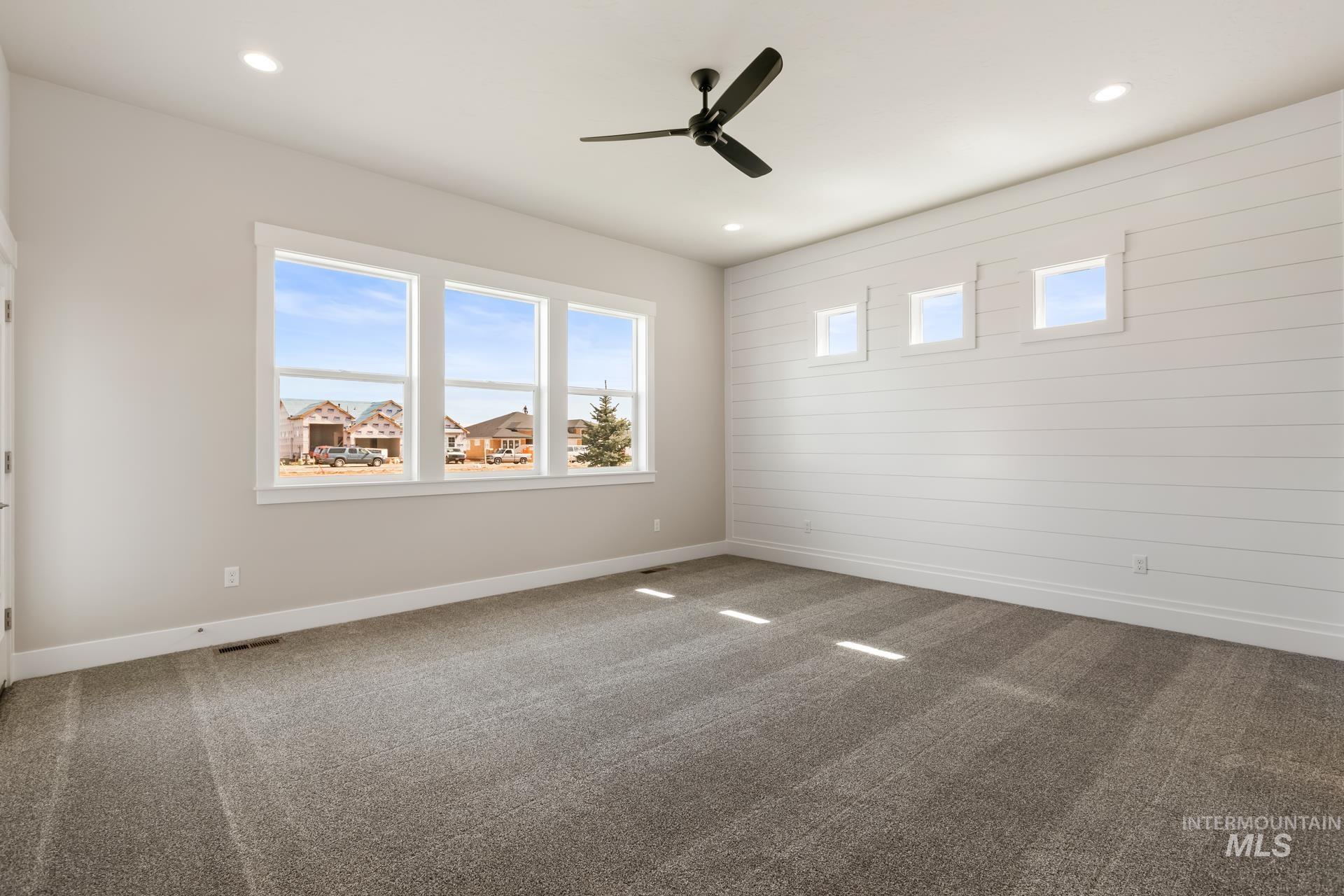 385 South Strut Way Boise, ID 83716 - Photo 21 of 30 Spare room with carpet, a ceiling fan, recessed lighting, and wooden walls