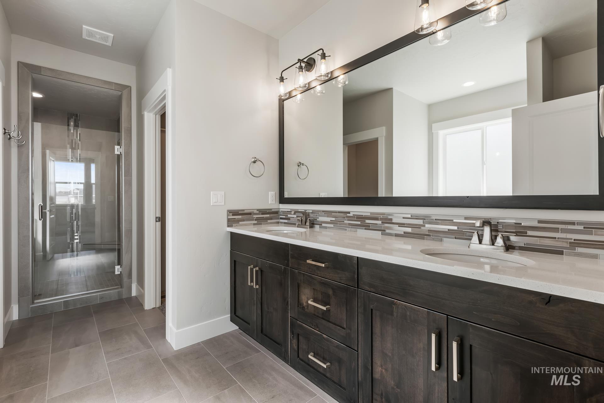 385 South Strut Way Boise, ID 83716 - Photo 23 of 30 Bathroom featuring double vanity, a stall shower, light tile patterned floors, recessed lighting, and tasteful backsplash